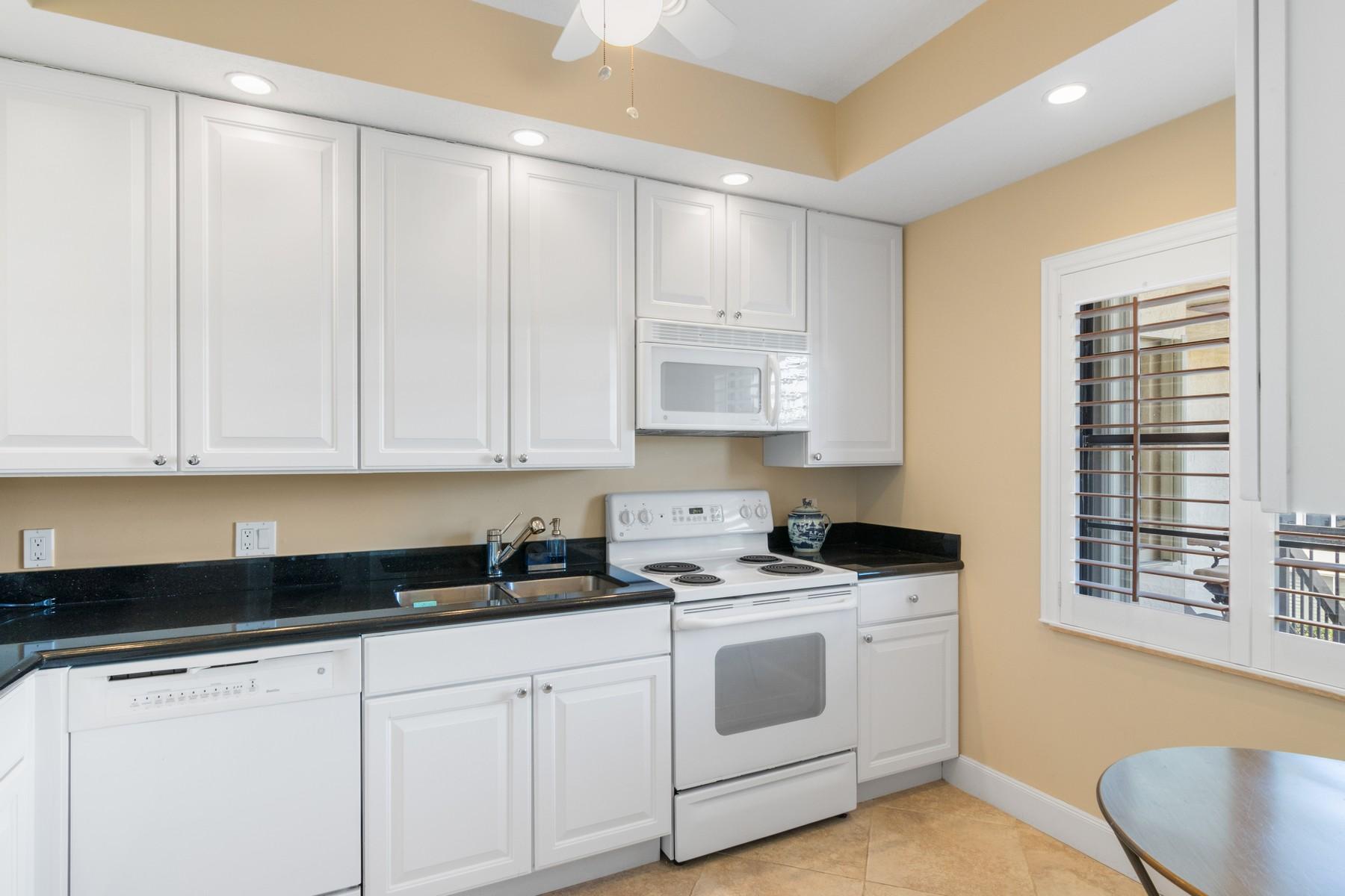275 South Beach Road, Unit C203 Jupiter, FL 33469 - Photo 10 of 21 a kitchen with granite countertop white cabinets and white appliances