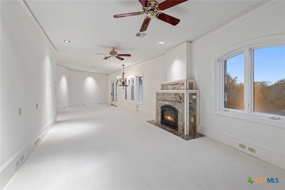 8536 Armstrong Road Belton, TX 76513 - Photo 28 of 41 a view of a livingroom with a fireplace a ceiling fan and windows