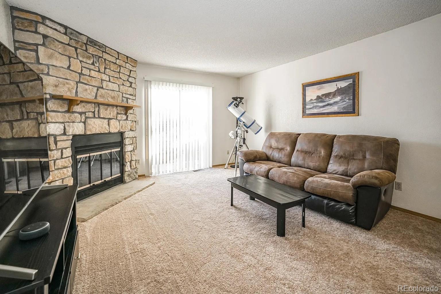 8280 South Fillmore Way Centennial, CO 80122 - Photo 7 of 10 a living room with furniture a flat screen tv and a window