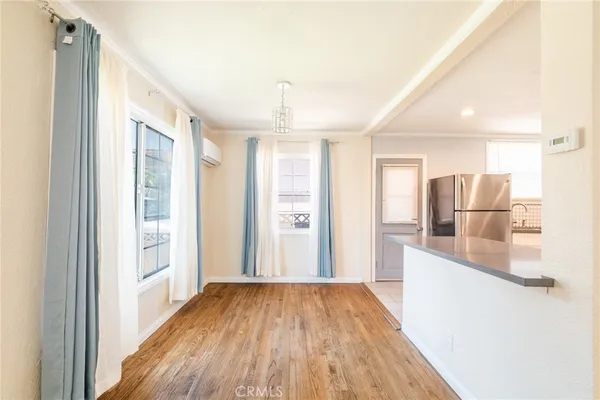 a view of a kitchen cabinets a refrigerator and wooden floor