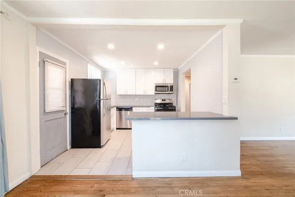 a kitchen with stainless steel appliances a refrigerator sink and microwave