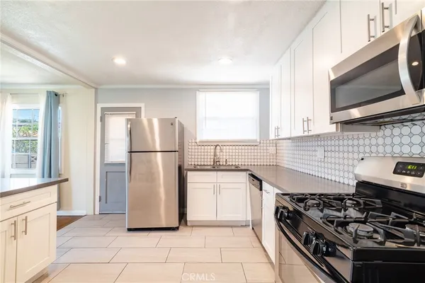 a kitchen with stainless steel appliances granite countertop a stove a refrigerator and a microwave
