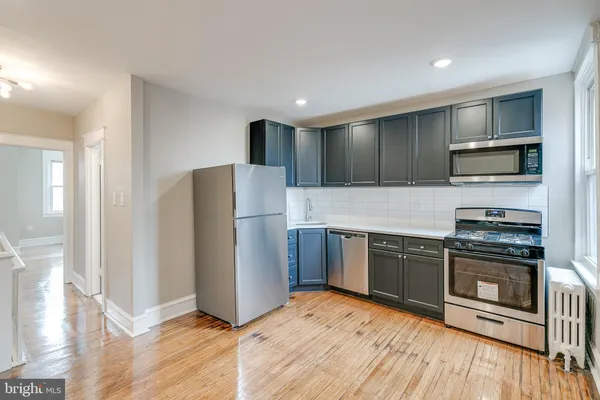 a kitchen with stainless steel appliances granite countertop a refrigerator stove and sink