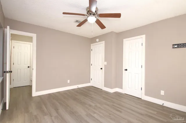 a view of room with hardwood floor and ceiling fan