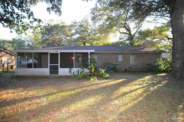 a front view of a house with a yard and potted plants