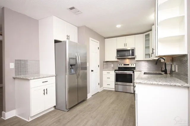 a kitchen with stainless steel appliances a refrigerator sink and microwave