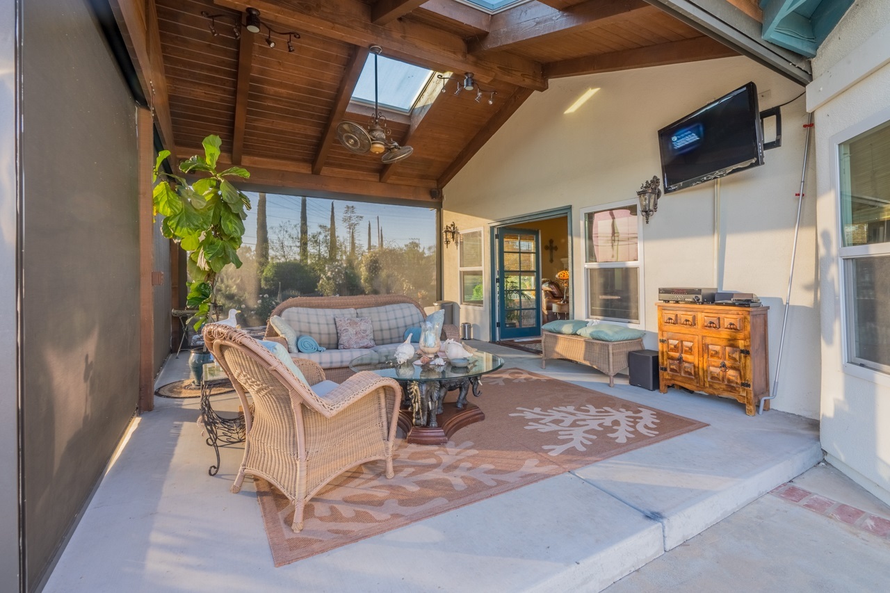 30133 Miller Road Valley Center, CA 92082 - Photo 8 of 25 California room extraordinary with automatic drop down screens to completely enclose the space. Ceiling fan, TV, Surround Sound, steps to Mission Pool, outdoor kitchen.
