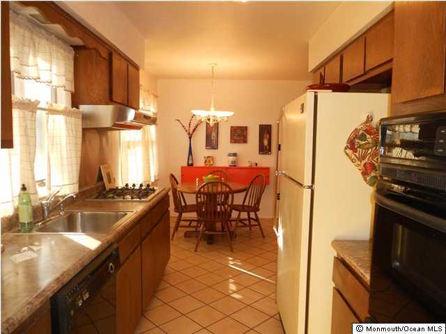 25 Kettle Creek Road Freehold, NJ 07728 - Photo 2 of 3 a kitchen with granite countertop a sink stove and refrigerator