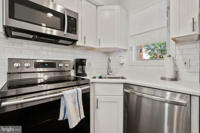 a kitchen with stainless steel appliances a stove a sink and a microwave