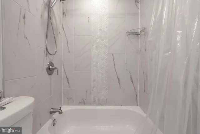 a bathroom with a bath tub with a shower
