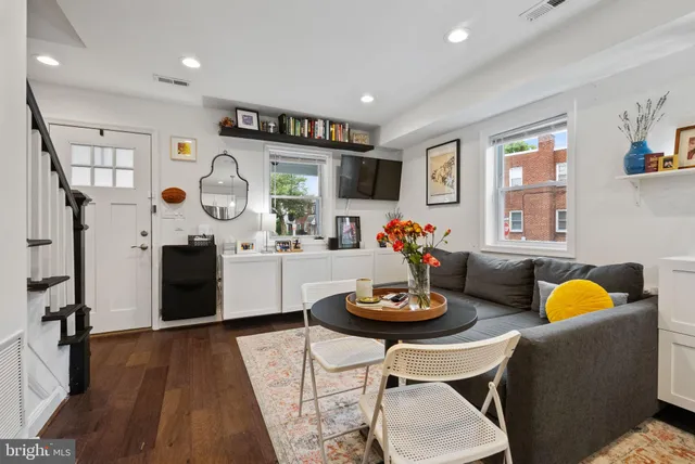 a living room with furniture and a wooden floor