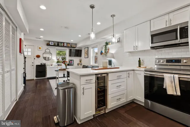 a kitchen with stainless steel appliances kitchen island granite countertop a stove a sink and a refrigerator