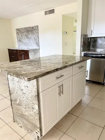 a view of a kitchen with granite countertop cabinets