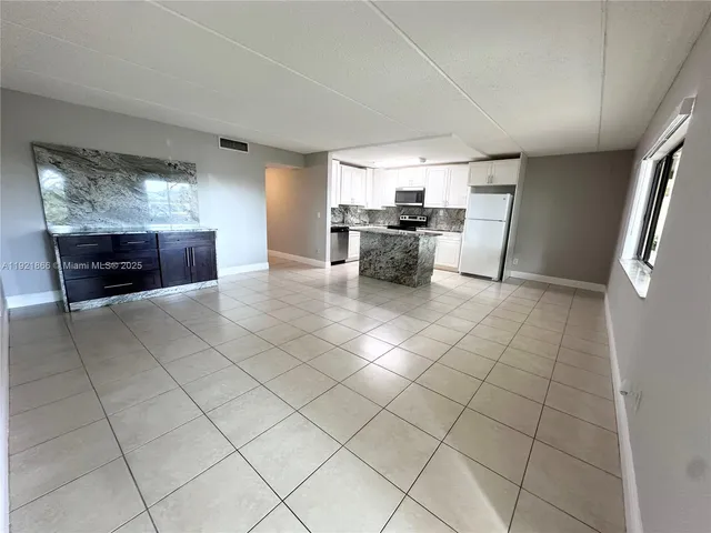 a kitchen with stainless steel appliances cabinets and front door