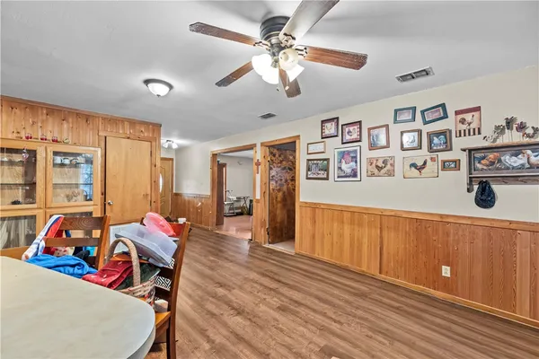 a view of a dining room with furniture cabinet and a chandelier fan
