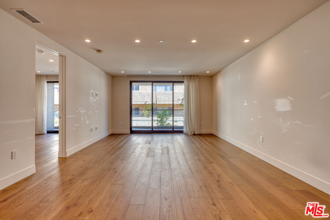 411 South Hamel Road, Unit 306 Los Angeles, CA 90048 - Photo 13 of 40 a view of an empty room with wooden floor and a window