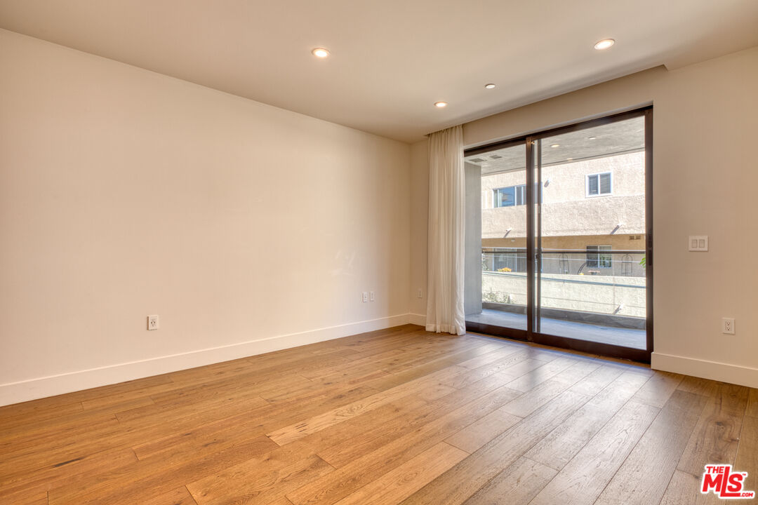 411 South Hamel Road, Unit 306 Los Angeles, CA 90048 - Photo 18 of 40 a view of an empty room with wooden floor and a window