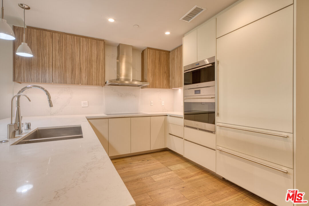411 South Hamel Road, Unit 306 Los Angeles, CA 90048 - Photo 6 of 40 a kitchen with stainless steel appliances a microwave sink and cabinets