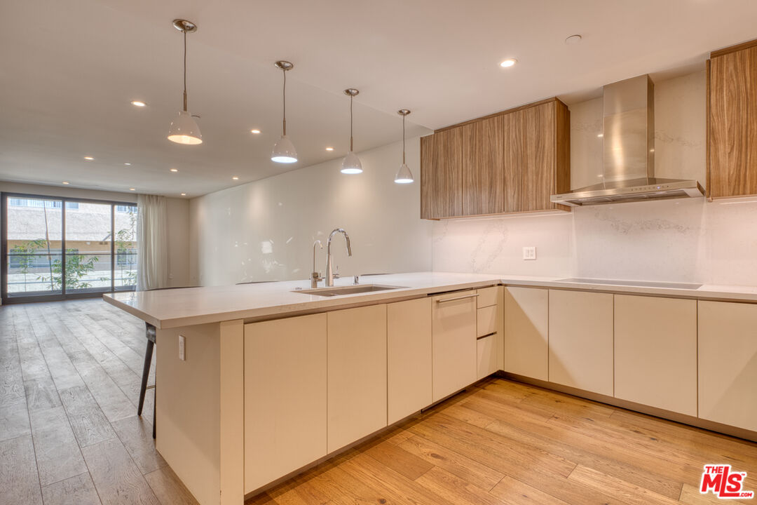 411 South Hamel Road, Unit 306 Los Angeles, CA 90048 - Photo 8 of 40 a kitchen with stainless steel appliances granite countertop a sink a stove and a wooden floors
