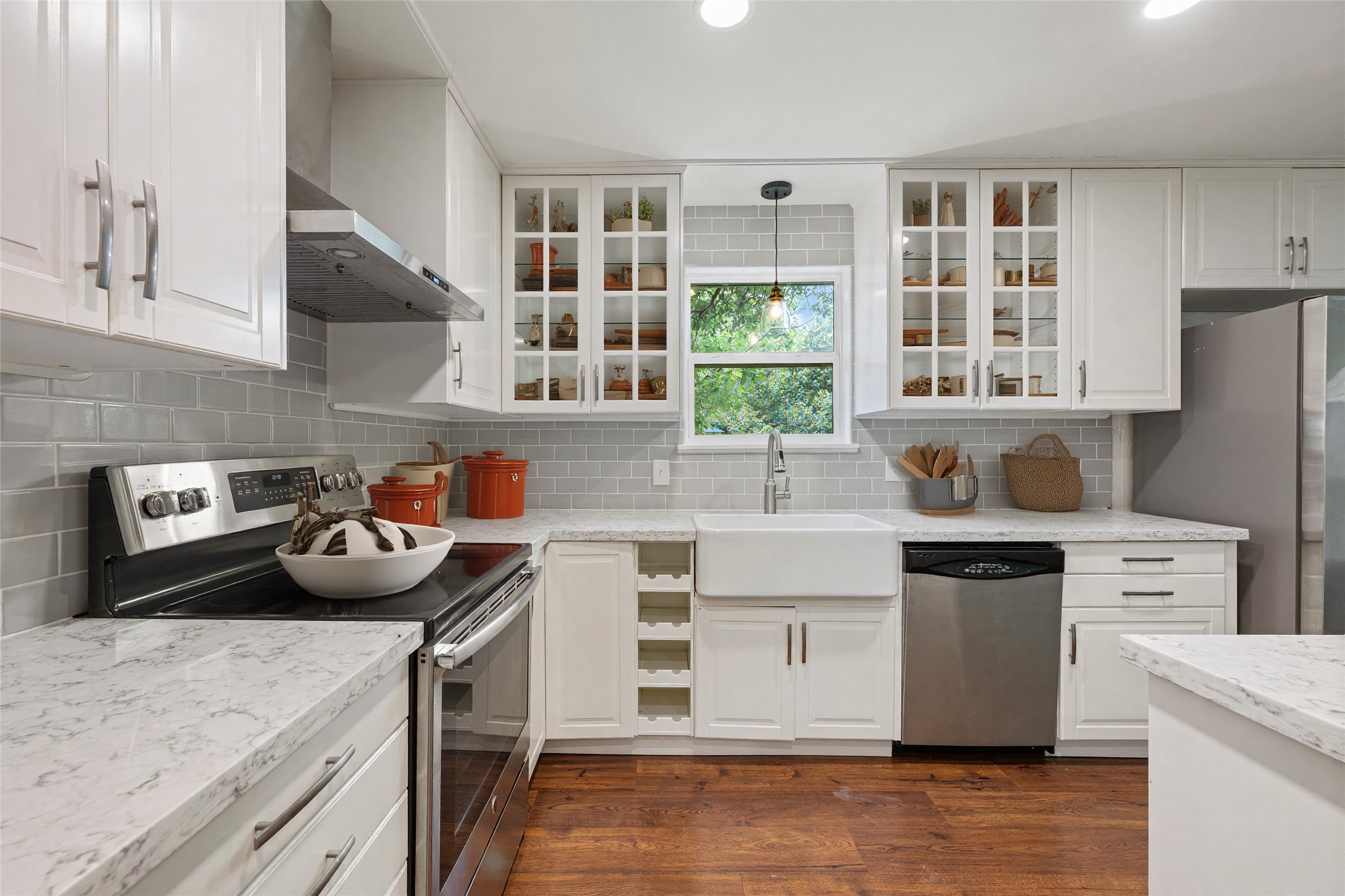 4602 Frontier Trail Austin, TX 78745 - Photo 8 of 21 A well-lit kitchen presents bright white cabinetry, quartz countertops, and lustrous hardwood flooring.