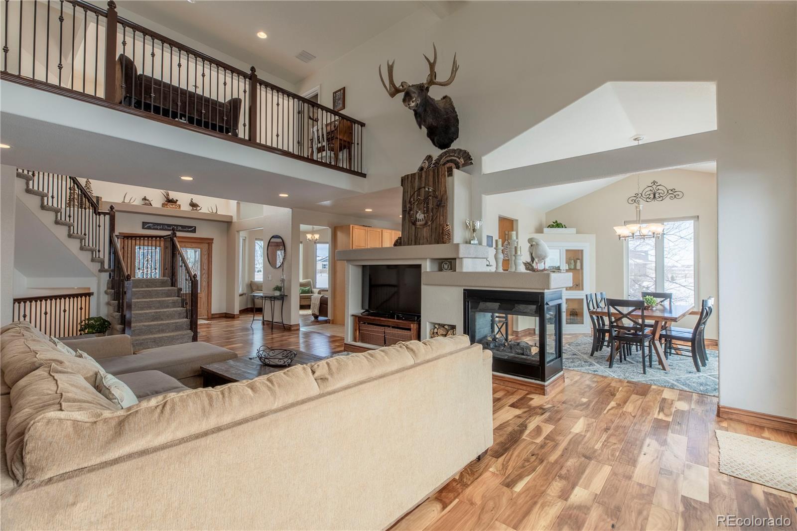 16504 Badminton Road North Platteville, CO 80651 - Photo 11 of 39 a living room with furniture a fireplace and a chandelier