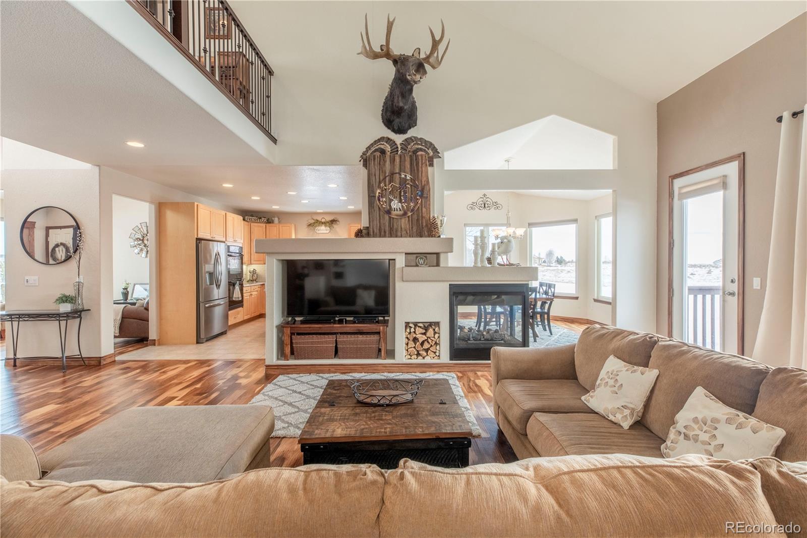 16504 Badminton Road North Platteville, CO 80651 - Photo 12 of 39 a living room with furniture a chandelier and a fireplace