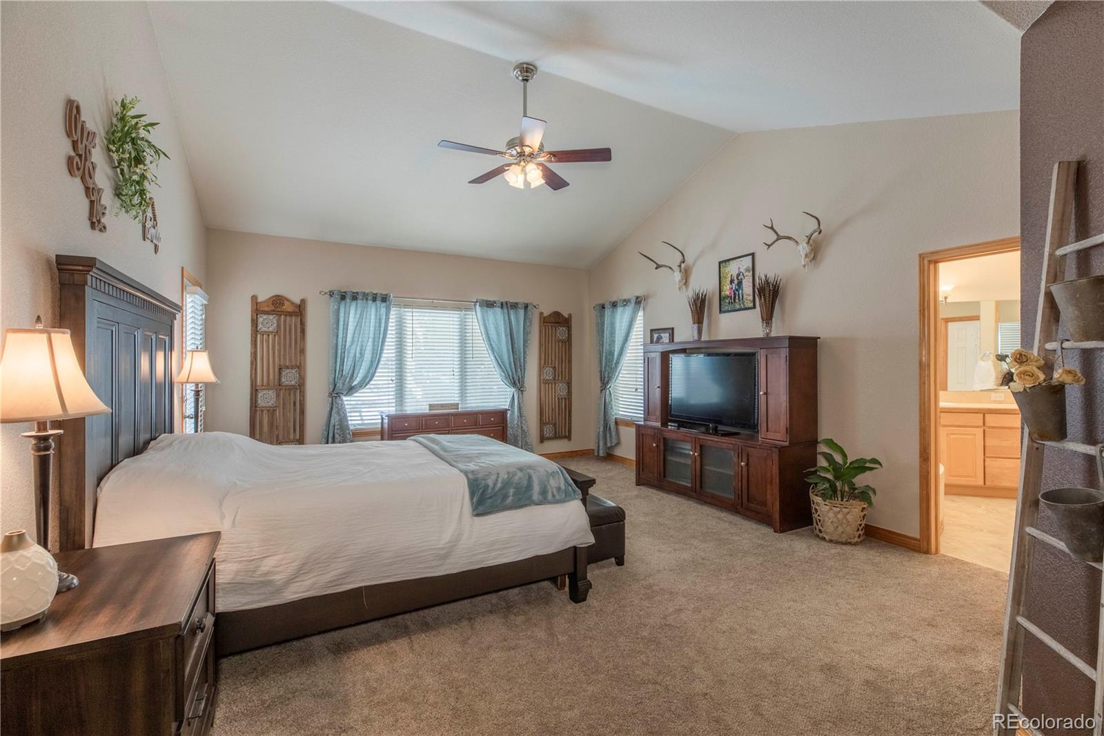 16504 Badminton Road North Platteville, CO 80651 - Photo 13 of 39 a bedroom with a bed and a chandelier