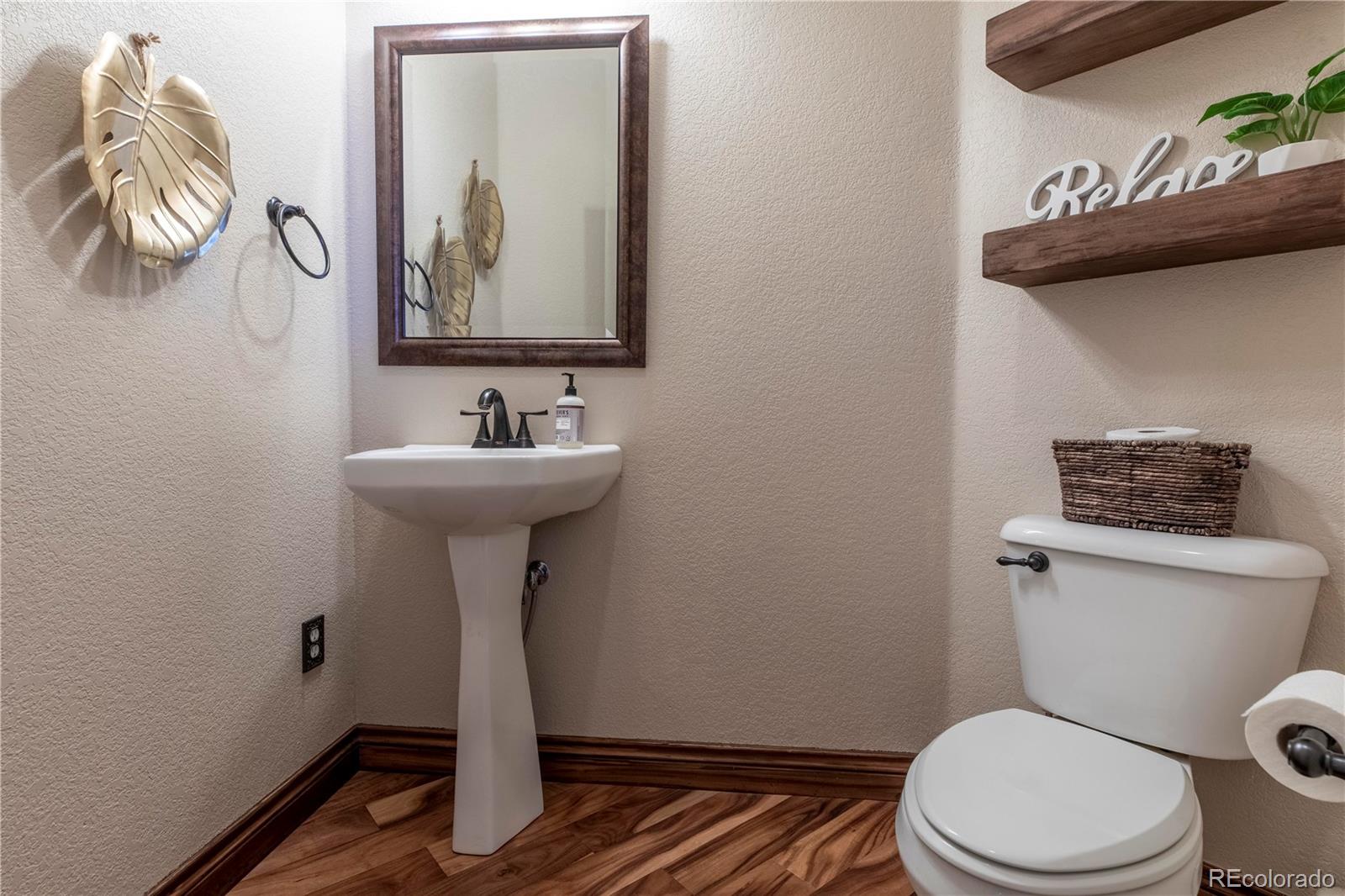 16504 Badminton Road North Platteville, CO 80651 - Photo 17 of 39 a bathroom with a toilet a sink and mirror