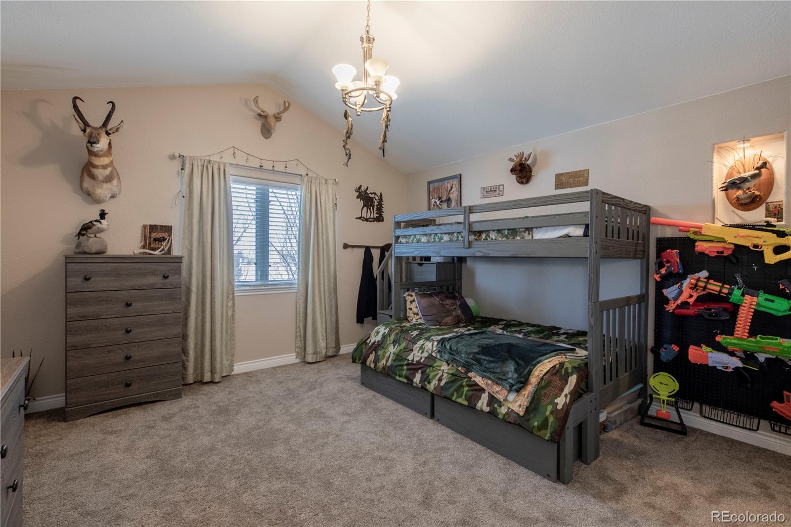 16504 Badminton Road North Platteville, CO 80651 - Photo 20 of 39 a bedroom with a bed and a chandelier