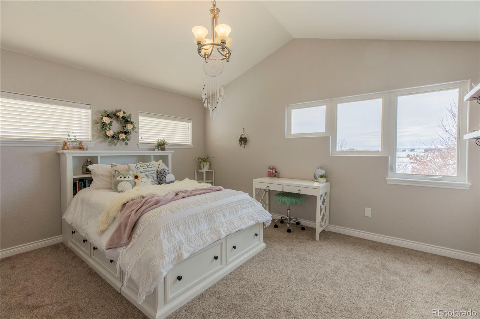 16504 Badminton Road North Platteville, CO 80651 - Photo 21 of 39 a bedroom with a bed and a chandelier