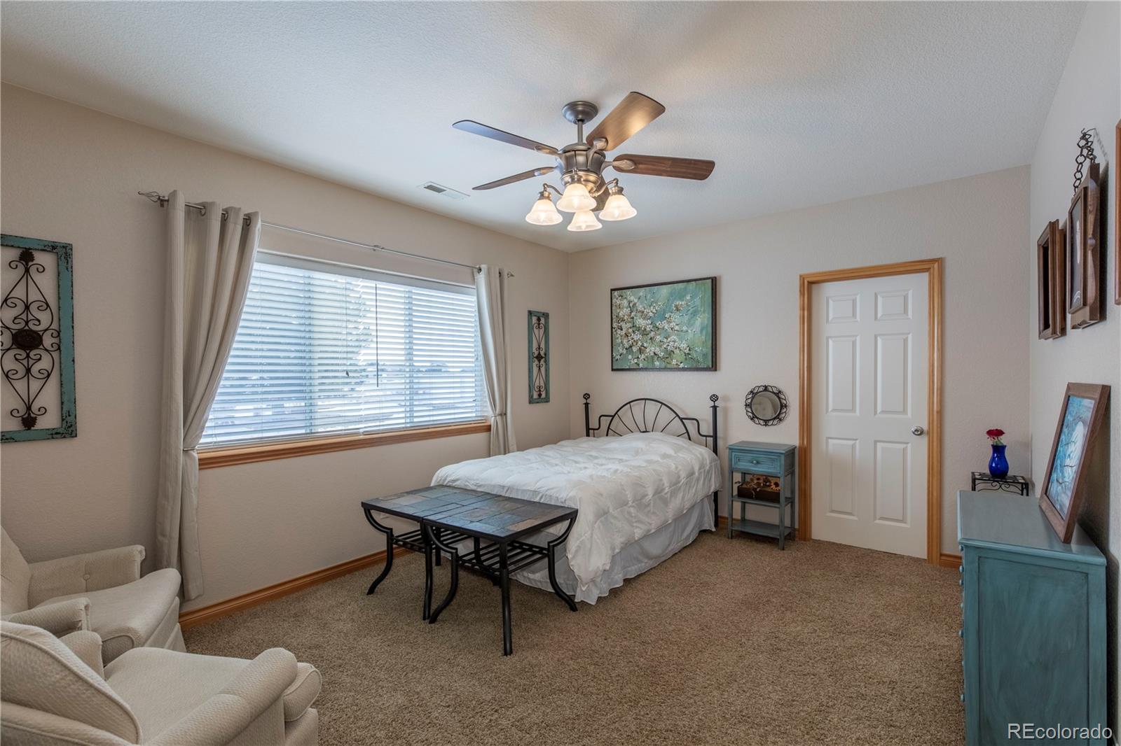 16504 Badminton Road North Platteville, CO 80651 - Photo 31 of 39 a spacious bedroom with a bed and a chandelier
