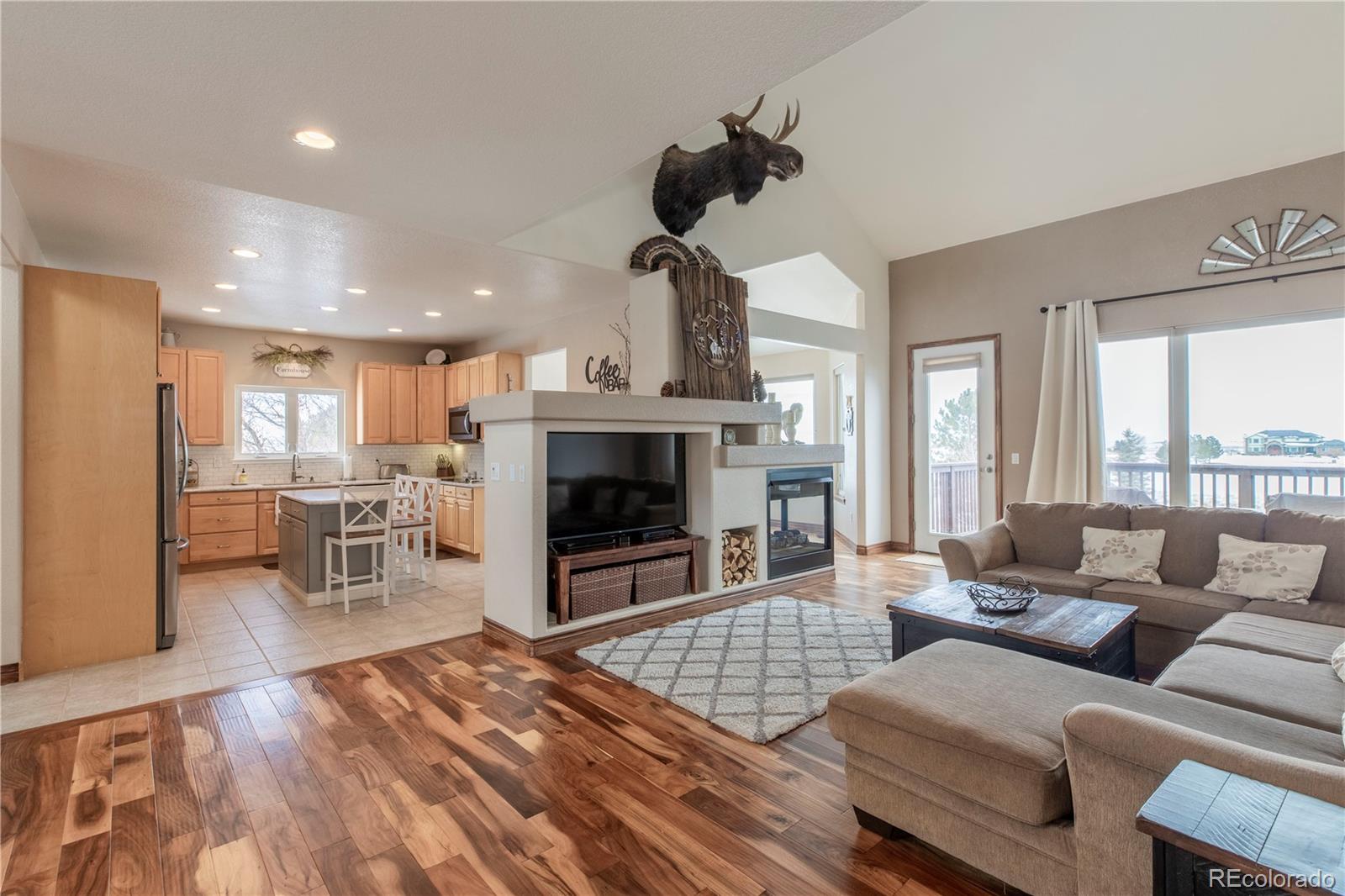 16504 Badminton Road North Platteville, CO 80651 - Photo 7 of 39 a living room with furniture large window and a fireplace