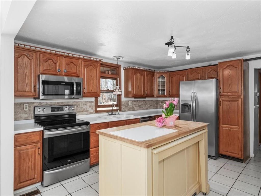 29 Profio Road McDonald, PA 15057 - Photo 7 of 44 a kitchen with stainless steel appliances kitchen island granite countertop a refrigerator stove and sink