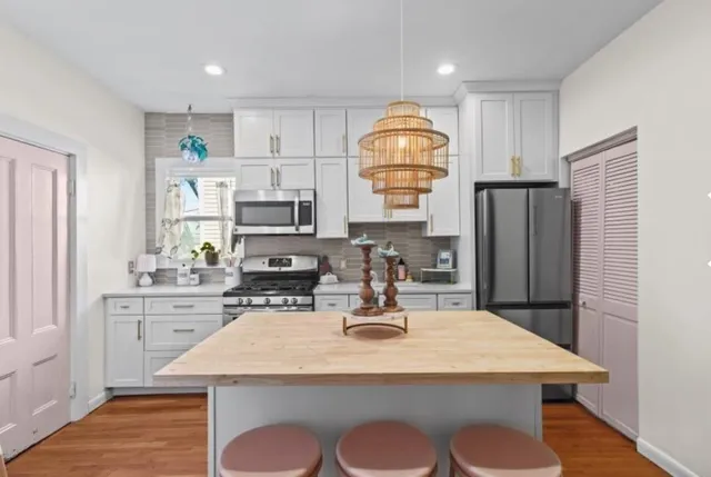 a kitchen with a appliances a refrigerator and a stove top oven