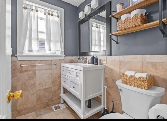 a bathroom with a sink toilet and window