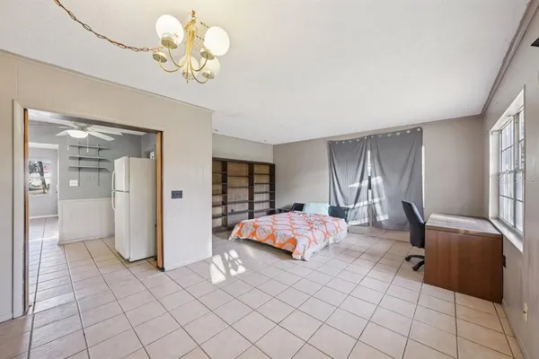 a spacious bedroom with a bed and a chandelier