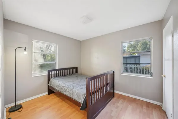 a bedroom with a bed and wooden floor