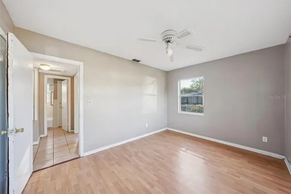 a view of a room with wooden floor and fan