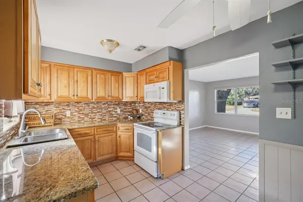 a kitchen with stainless steel appliances granite countertop a sink and a stove