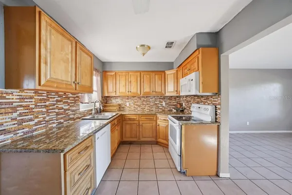 a kitchen with stainless steel appliances granite countertop a sink and a stove