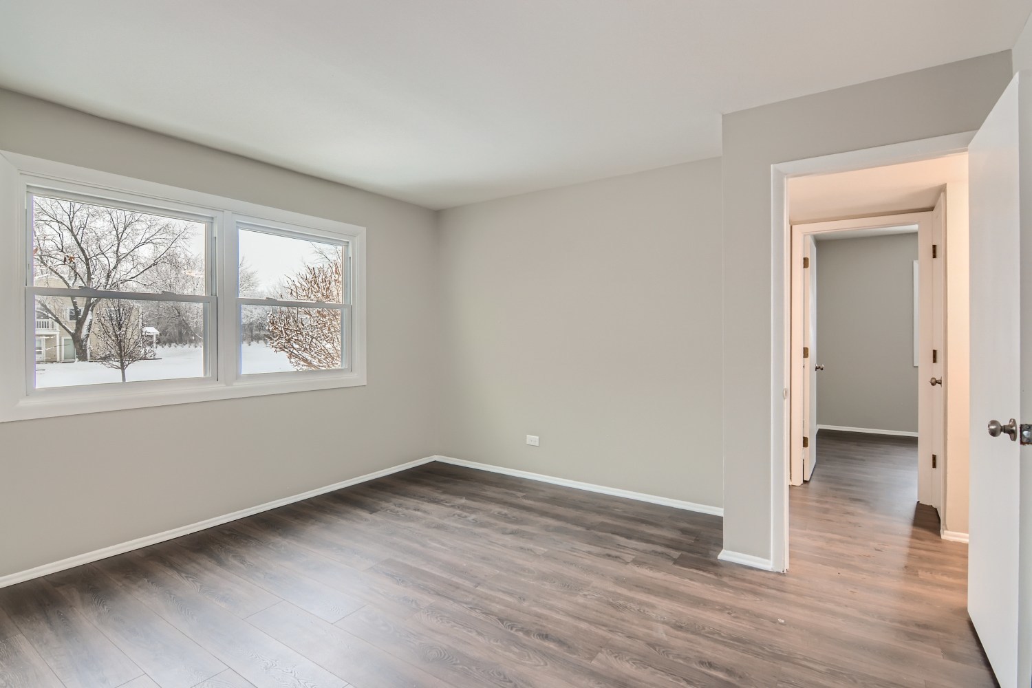 185 Rita Court, Unit A Bartlett, IL 60103 - Photo 6 of 11 a view of an empty room with wooden floor and a window