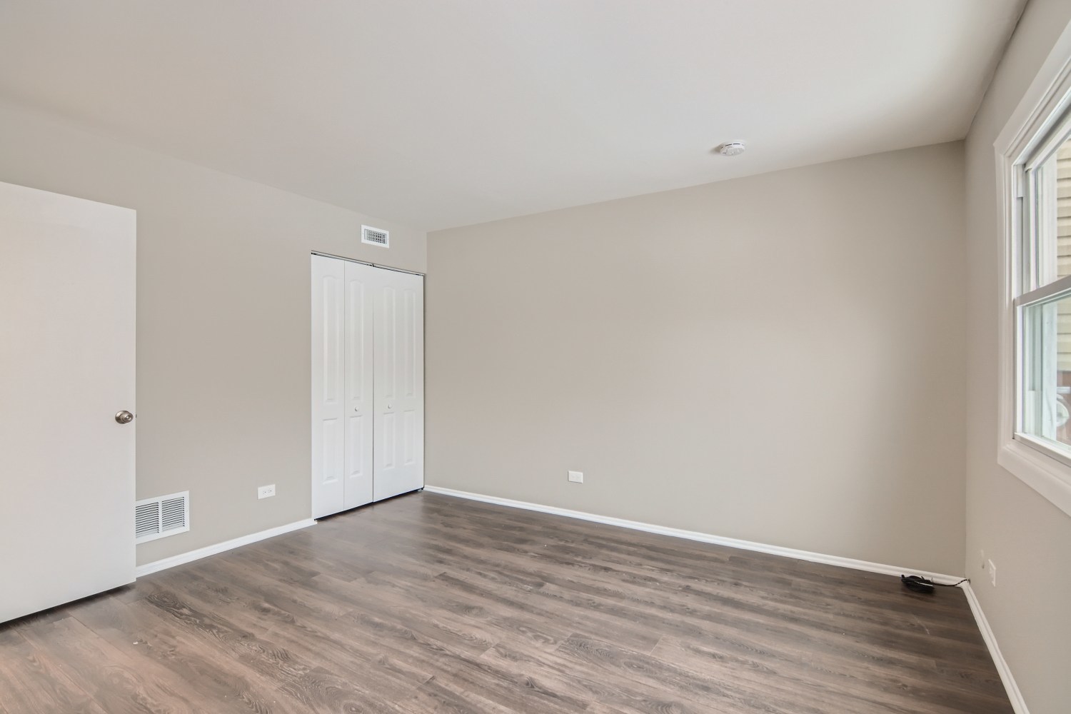 185 Rita Court, Unit A Bartlett, IL 60103 - Photo 7 of 11 a view of an empty room with wooden floor and a window