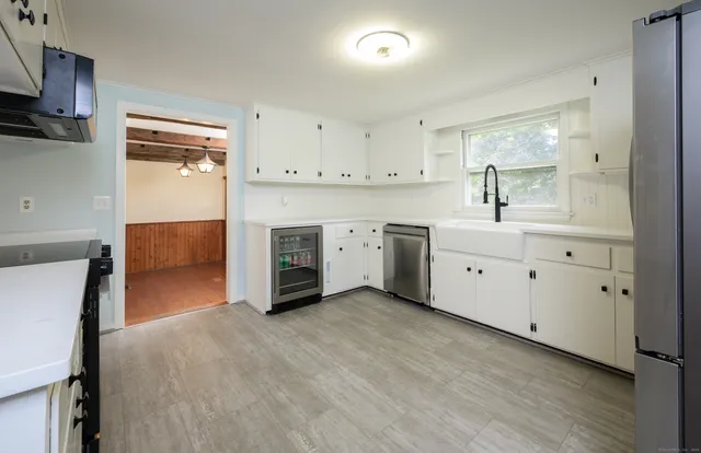 a view of kitchen with granite countertop white cabinets and white appliances