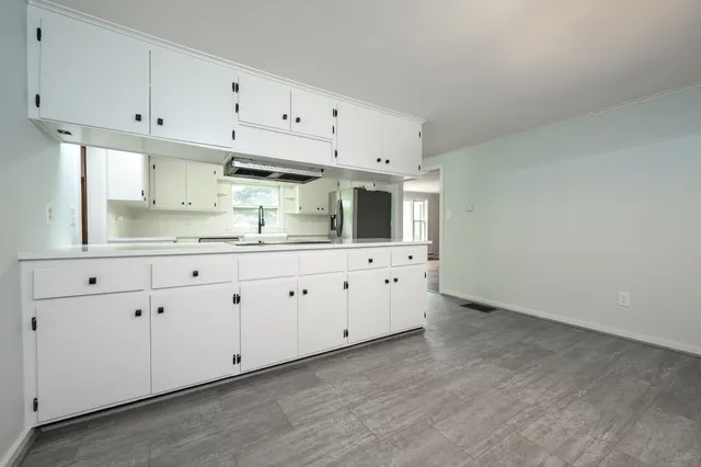 a kitchen with white cabinets and white appliances