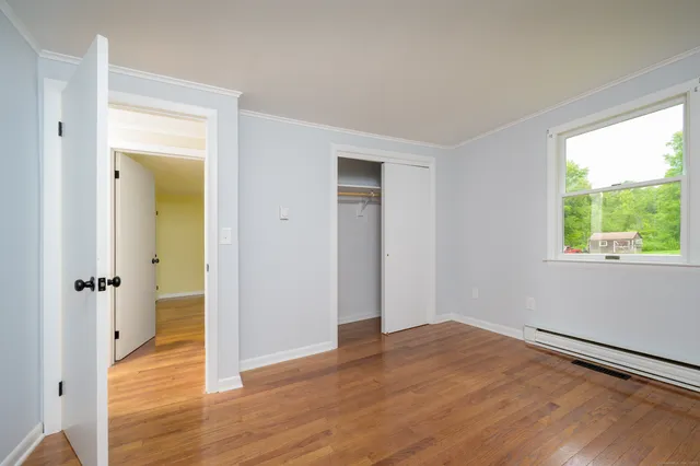 a view of a room with wooden floor and a window