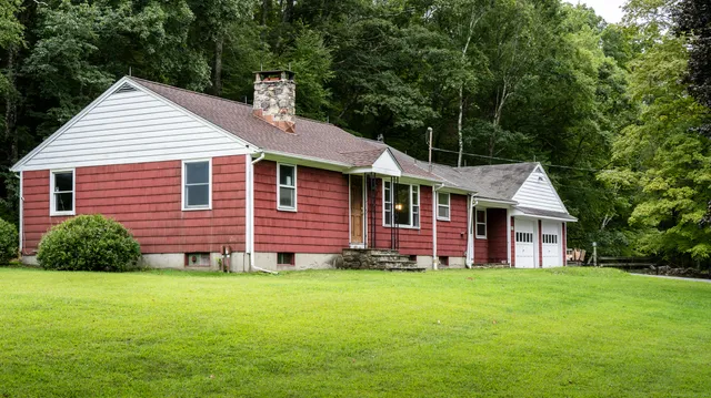 a front view of house with yard and green space