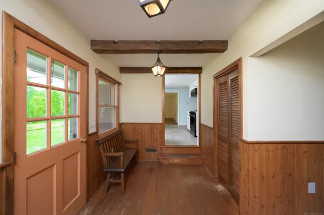 a view of a hallway with furniture and a window