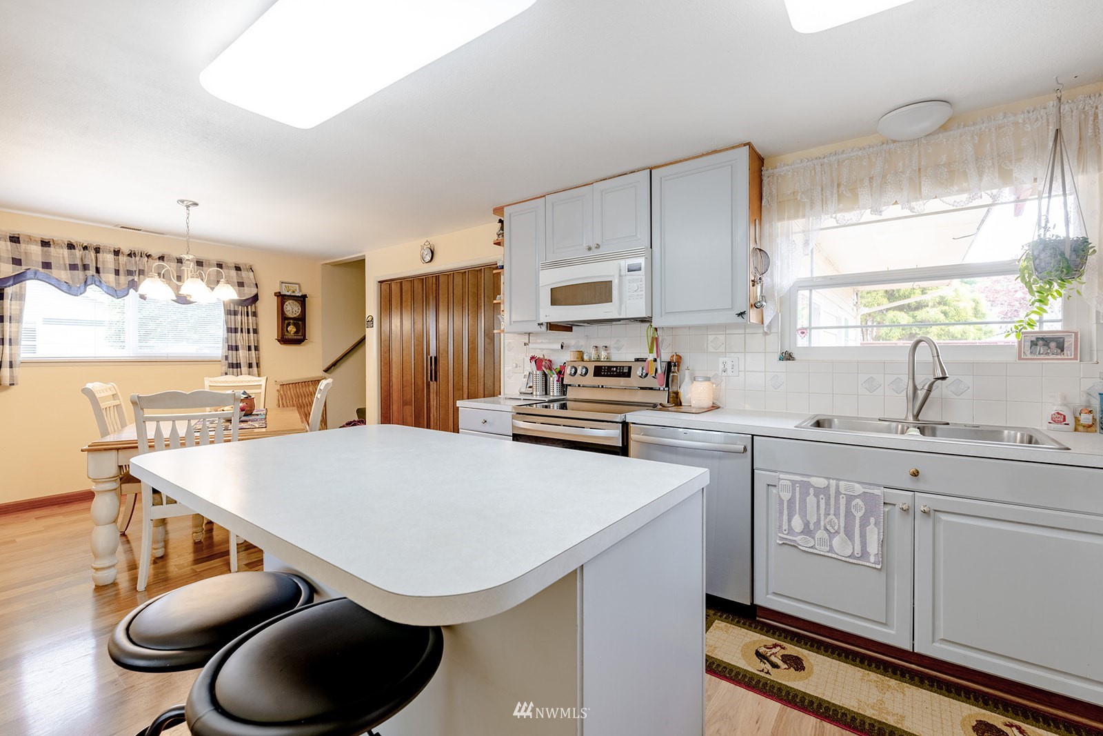 1209 Dundee Drive Cosmopolis, WA 98537 - Photo 25 of 36 a kitchen with stainless steel appliances a sink a stove a refrigerator cabinets and a refrigerator