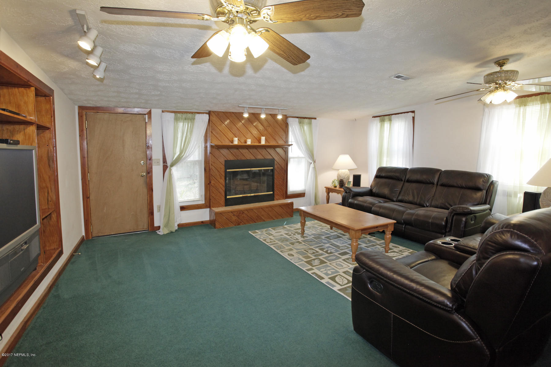 4956 Spring Glen Road Jacksonville, FL 32207 - Photo 11 of 23 a living room with furniture a fireplace and a chandelier