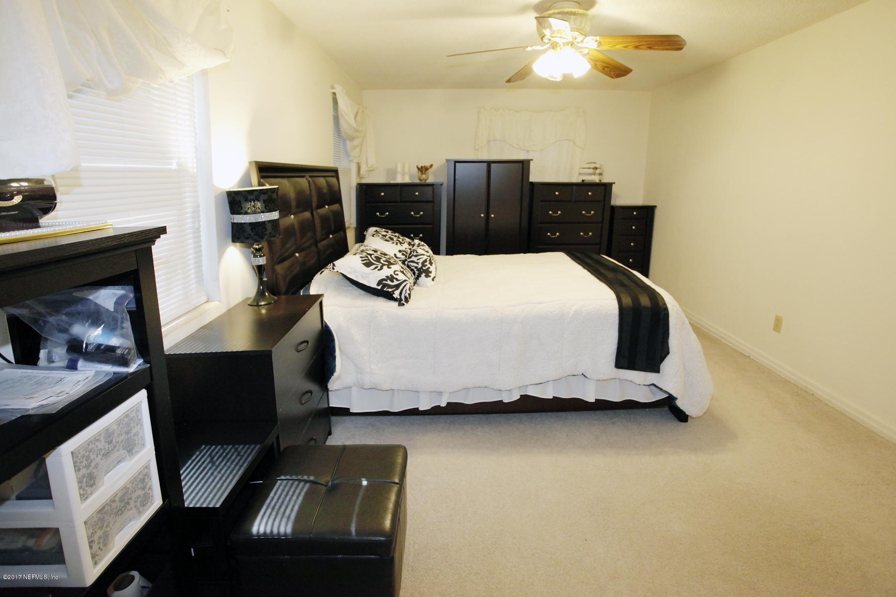 4956 Spring Glen Road Jacksonville, FL 32207 - Photo 14 of 23 a bedroom with a bed and a chandelier